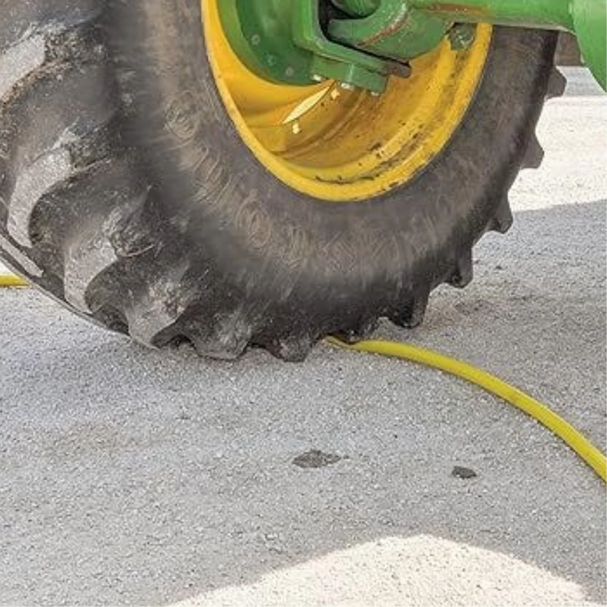 Dramm ColorStorm Yellow Hose under tractor tire